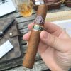 A person holding mentecristo eagle open series cigar